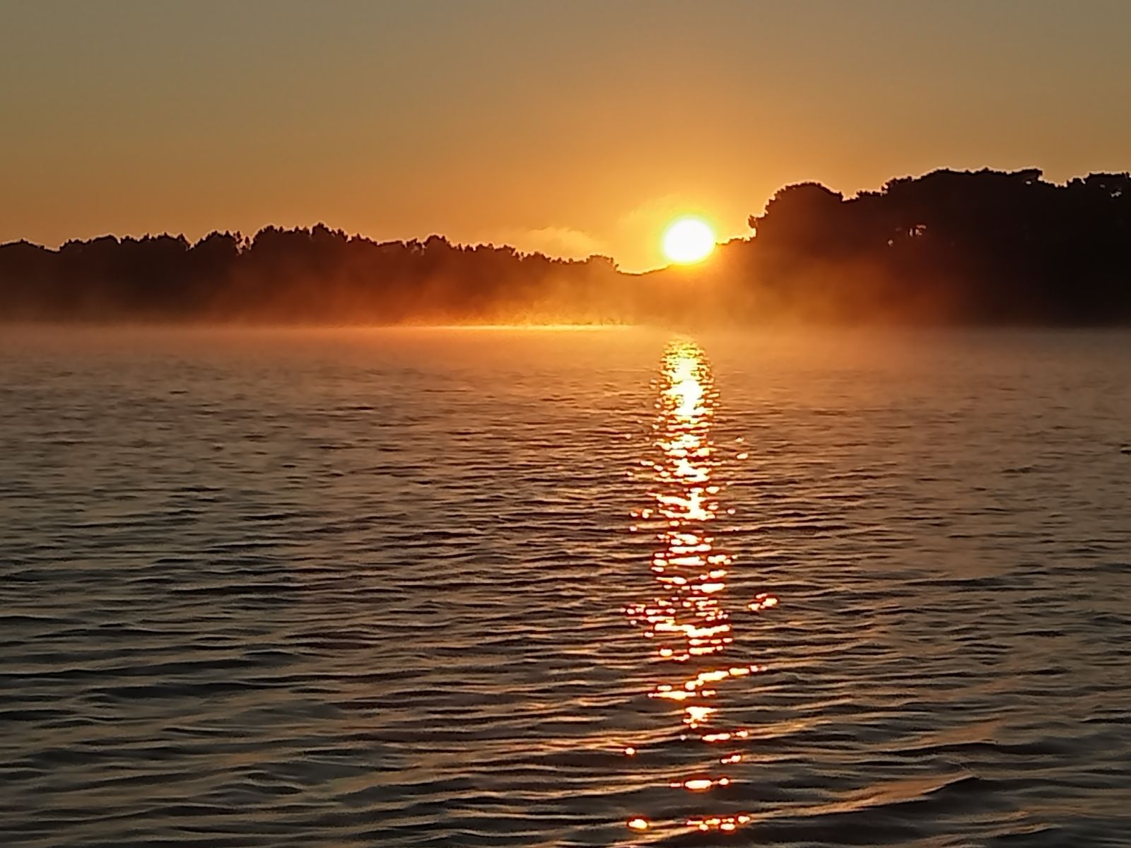 Lever de soleil sur l'eau, un chemin de lumière ouvert devant